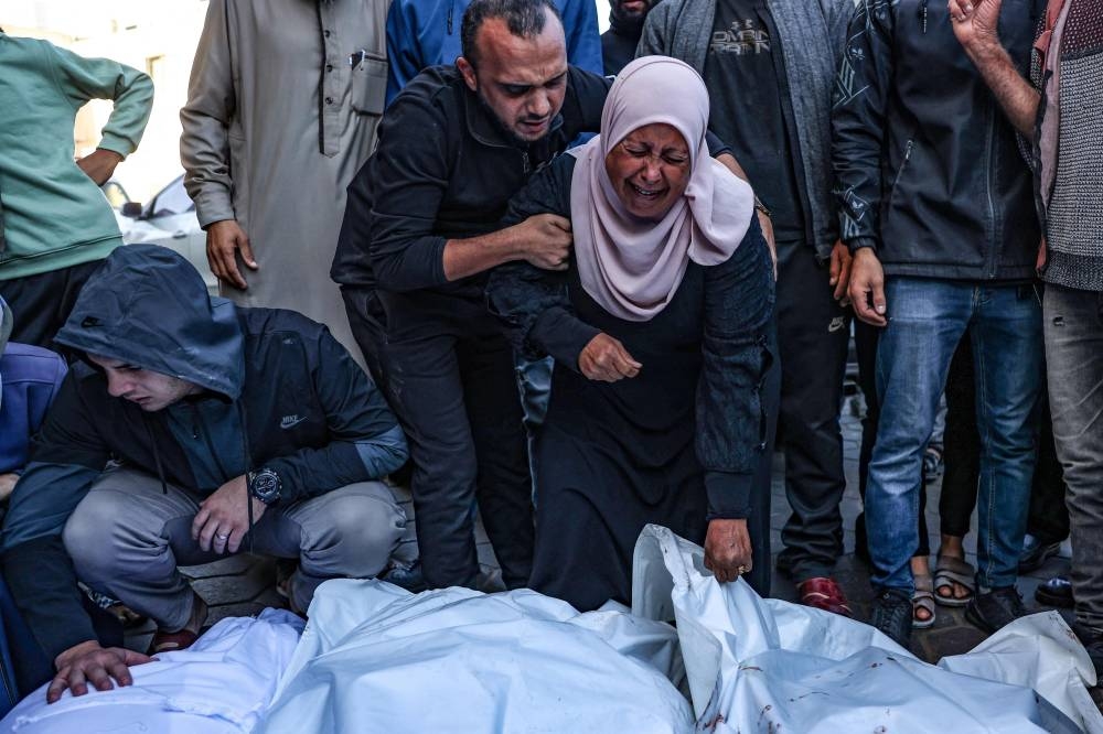Palestinians react in front of the bodies people killed in an Israeli strike, at the al-Aqsa Martyrs Hospital in Deir Al-Balah in the central Gaza Strip, on Sunday. AFP