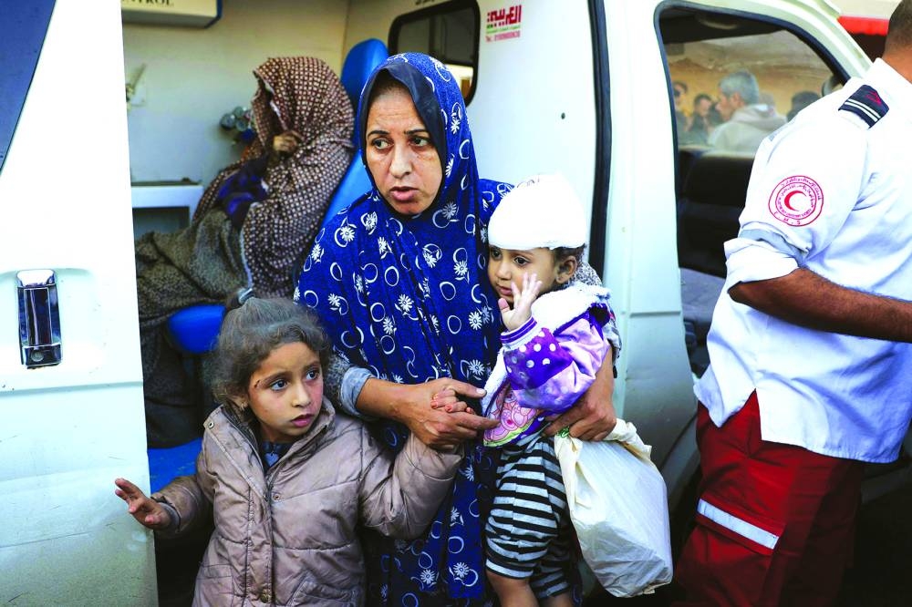 Palestinian women and children injured in an Israeli strike, wait in an ambulance in front of the Al-Aqsa Martyrs Hospital in Deir Al-Balah in the central Gaza Strip, yesterday.