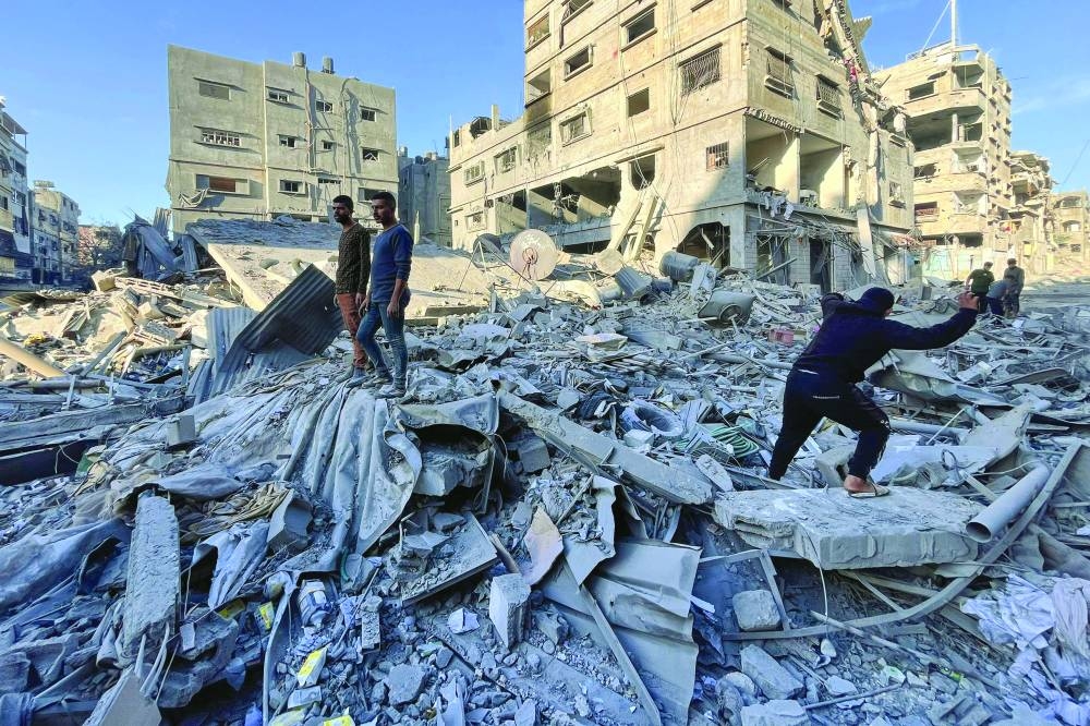 
People check the rubble of a building hit in an overnight Israeli strike in Beit Lahia in the northern Gaza Strip, yesterday. 