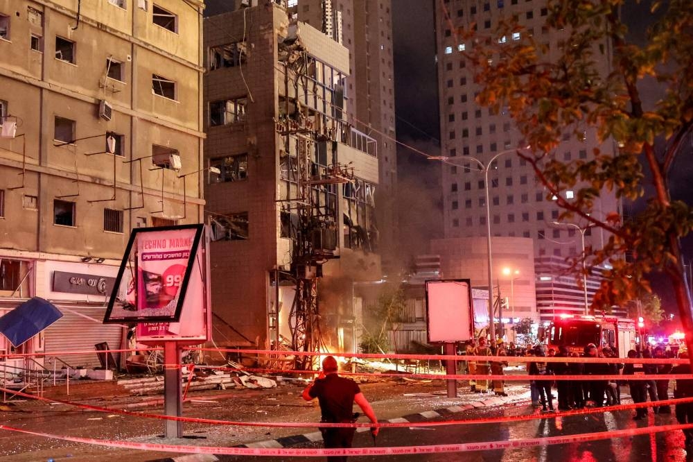 Israeli security services stand in front of a heavily damaged building at the site of a rocket attack from southern Lebanon in Ramat Gan, north of Tel Aviv, on Monday. AFP