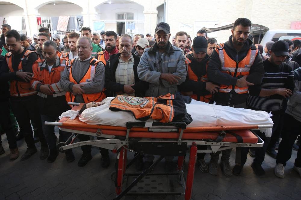 Palestinians pray over the body of a member of the civil defence, killed the previous night in an Israeli airstrike, at Al-Ahli Arab hospital, also known as the Baptist hospital, in Gaza City on Wednesday. AFP