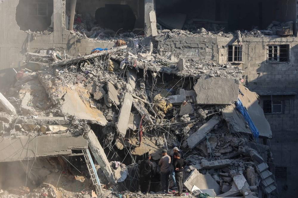 Palestinians check the rubble of a building in the aftermath of an Israeli strike south of Gaza City on Friday. AFP