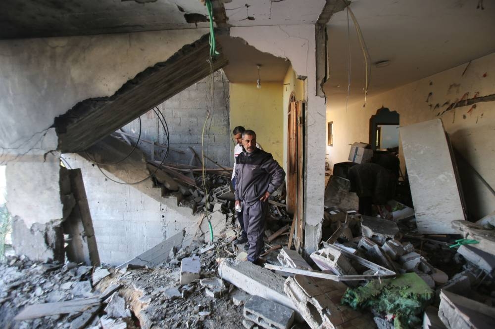 Men check the site on an Israeli strike at a house in Nuseirat in the central Gaza Strip on Friday. AFP