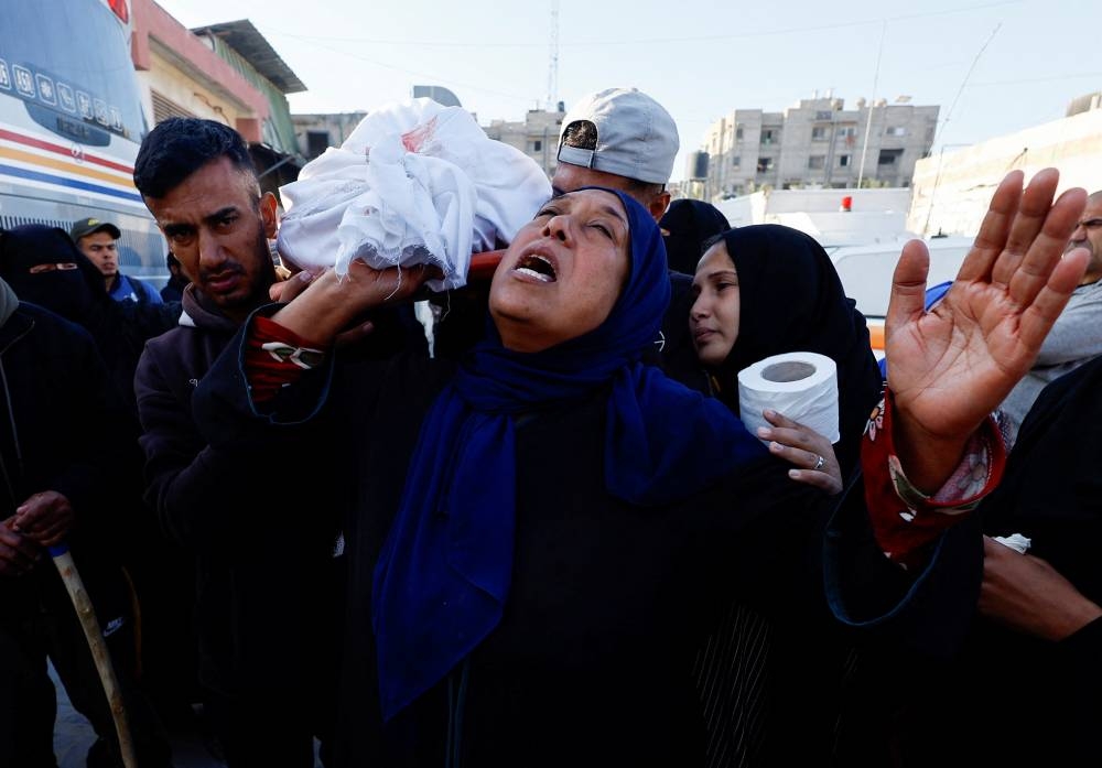 Mourners react as they carry the body of a Palestinian killed in an Israeli strike, at Nasser hospital in Khan Younis in the southern Gaza Strip, on Saturday. REUTERS