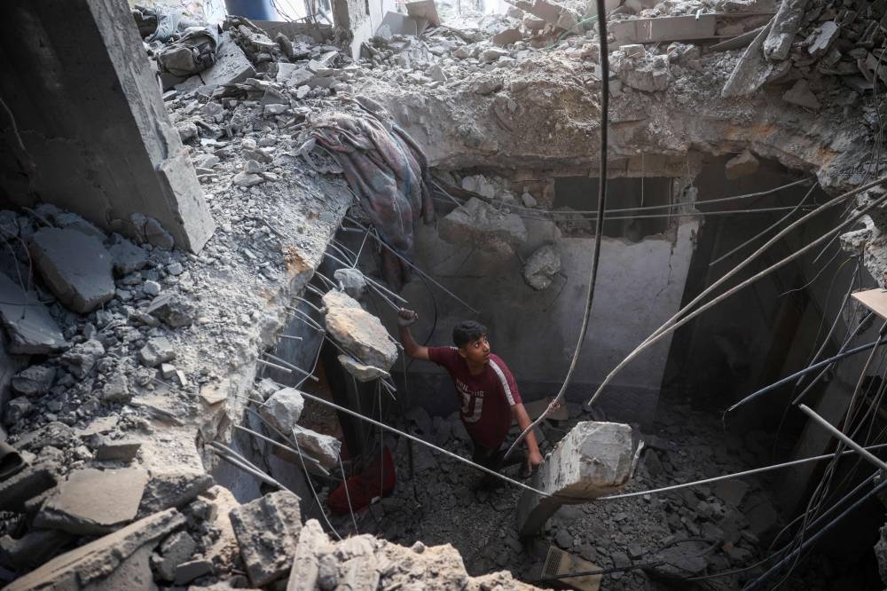 A Palestinian inspects the rubble of a house that was destroyed in an Israeli strike at the Bureij refugee camp in the central Gaza Strip, on Sunday. AFP