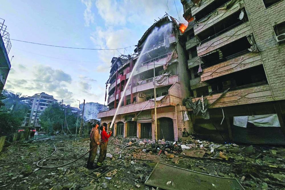 Firefighters douse the flames at the site of an Israeli air strike that targeted the Al-Hadath area near Beirut’s southern suburbs, on Sunday.