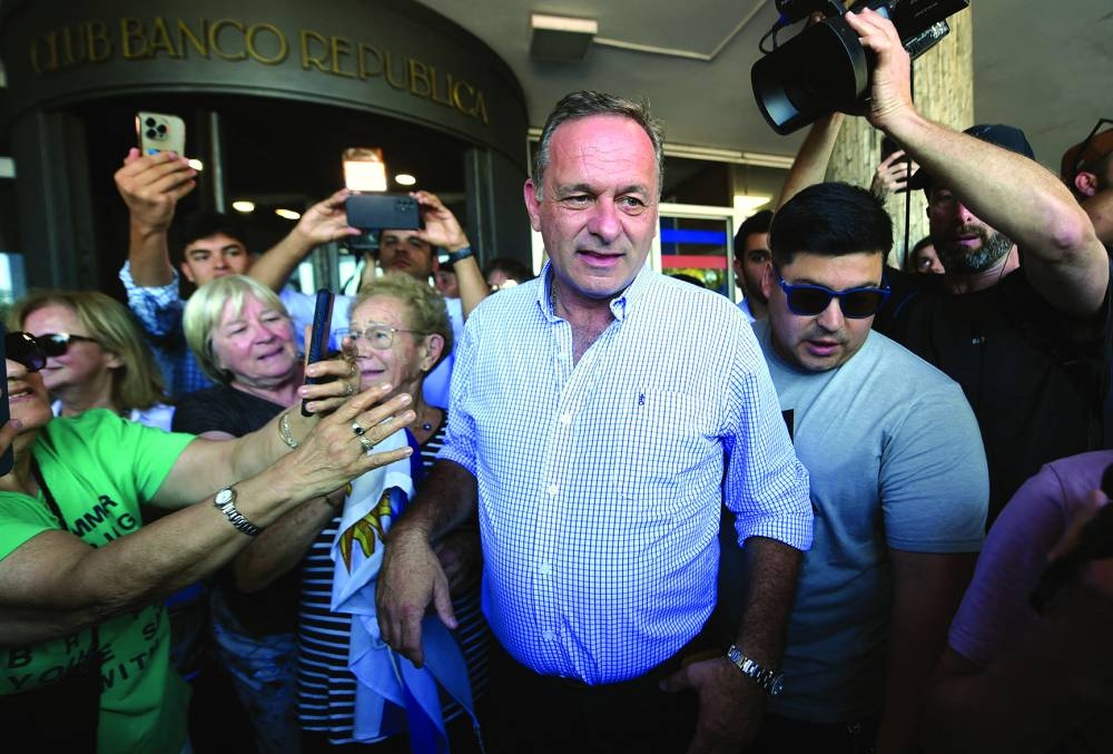 Uruguay's presidential candidate for the Republican Coalition, Alvaro Delgado (C), leaves after voting during the presidential runoff election in Montevideo on November 24, 2024. Uruguayans headed to the polls Sunday, with former history teacher Yamandu Orsi of the leftist Frente Amplio (Broad Front) and ex-veterinarian Alvaro Delgado of the National Party, a member of outgoing President Luis Lacalle Pou's center-right Republican Coalition, going head-to-head. (Photo by DANTE FERNANDEZ / AFP)