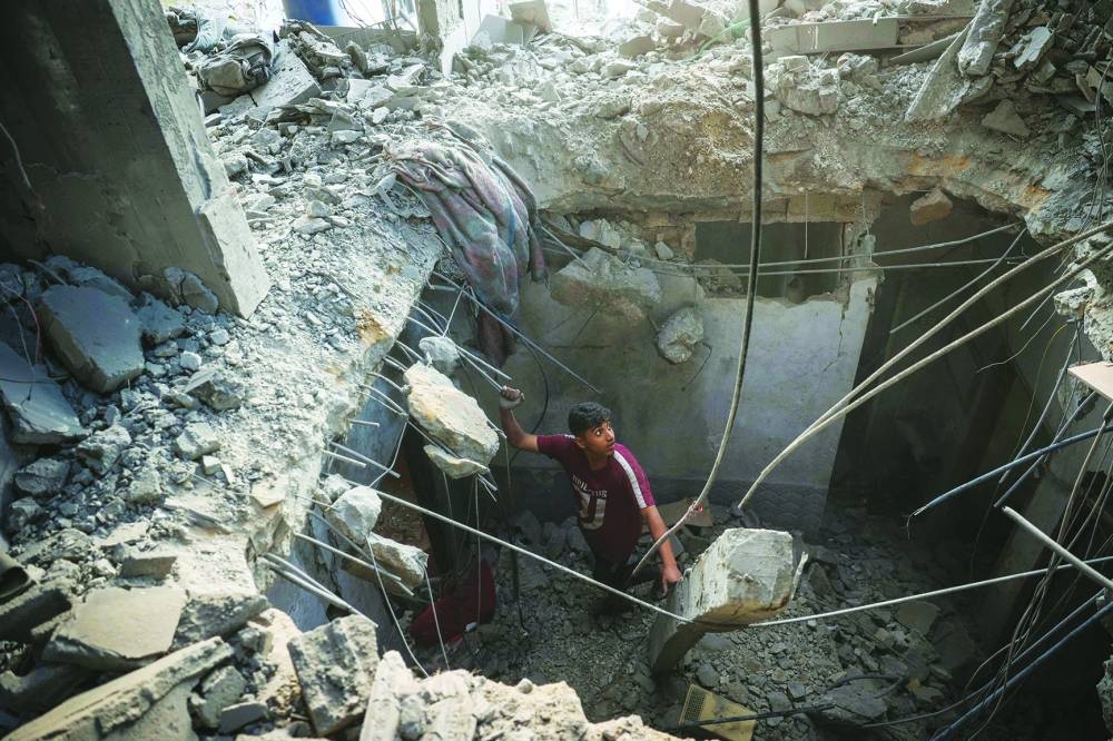 A Palestinian inspects the rubble of a house that was destroyed in an Israeli strike at the Bureij refugee camp in the central Gaza Strip Sunday,