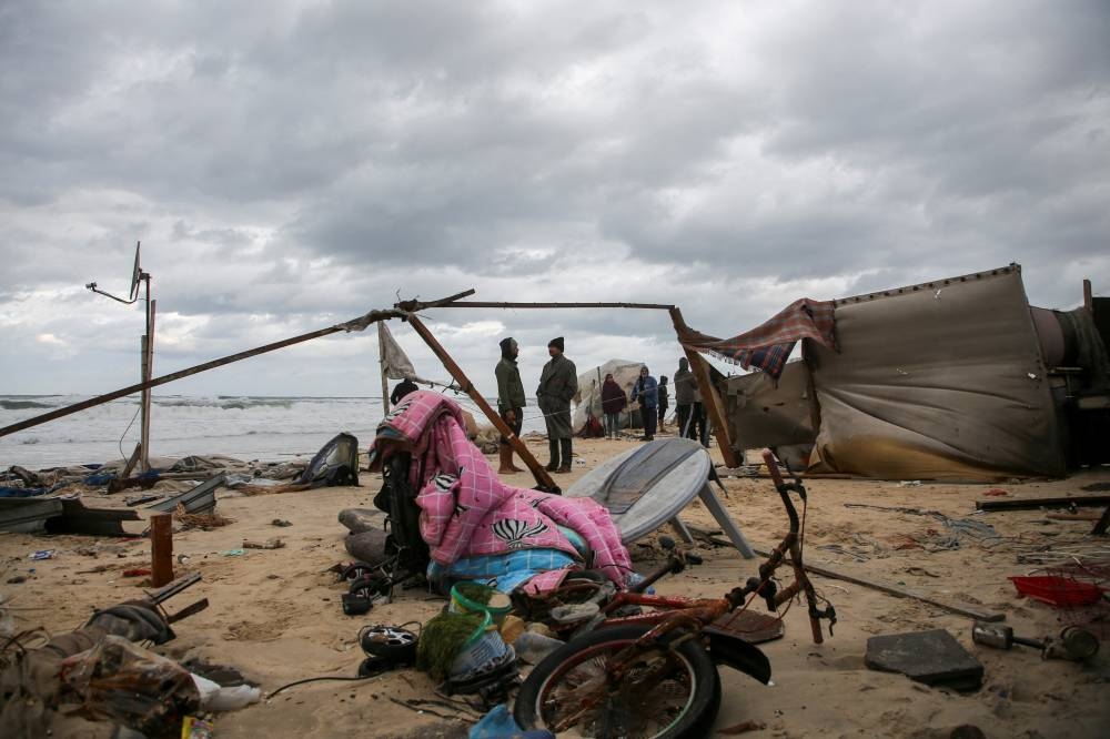 Palestinians assess the damage to tents used by displaced people, following rising sea levels and heavy rainfall, in Khan Younis in the southern Gaza Strip, on Monday. REUTERS