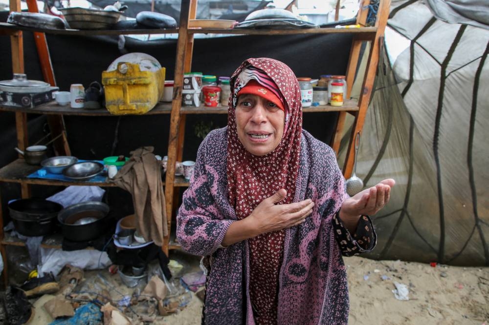 A displaced Palestinian woman reacts at her flooded tent following rising sea levels and heavy rainfall in Khan Younis in the southern Gaza Strip, on Monday. REUTERS