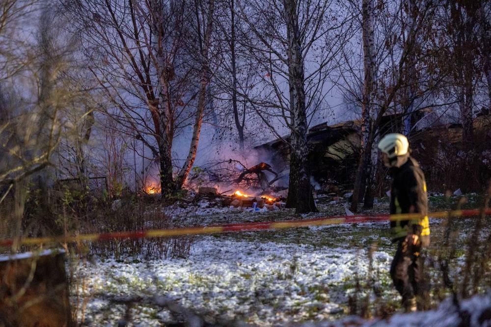 Rescuer walks past DHL cargo plane wreckage, at the crash site near Vilnius International Airport, Lithuania, on Monday. Lukas Balandis/BNS via REUTERS
