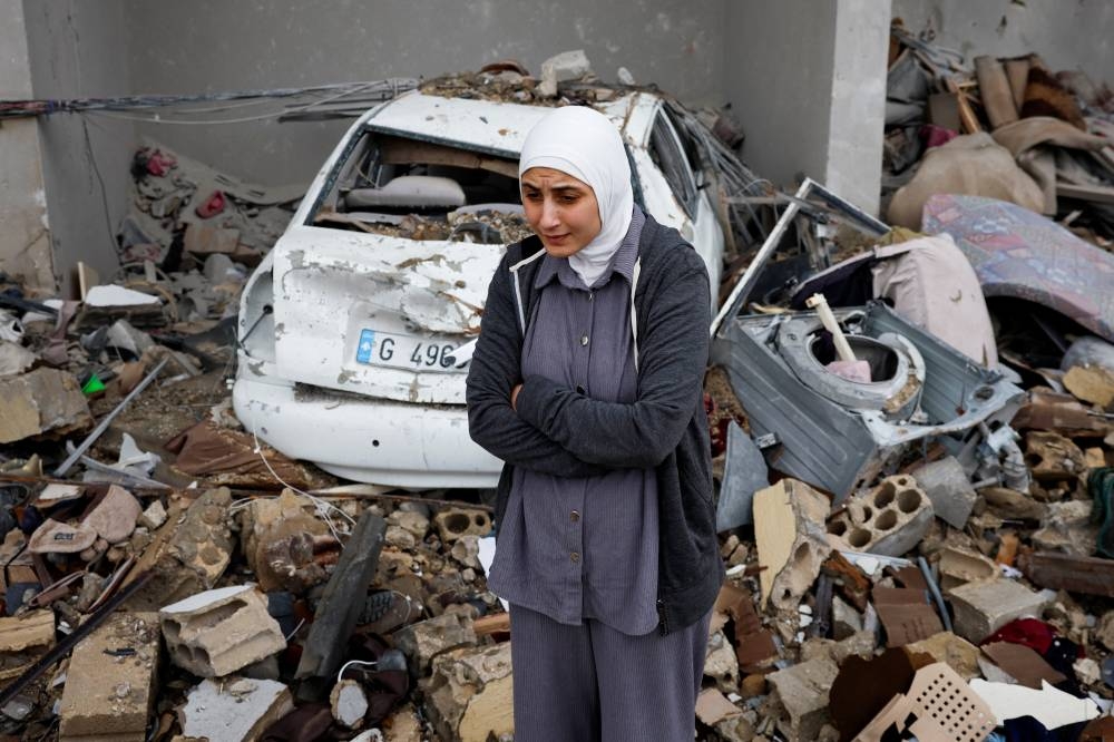 Nadin Bajouk, 24, stands among the rubble of her house, after a ceasefire between Israel and Hezbollah took effect, in Tyre, Lebanon, on Wednesday. REUTERS