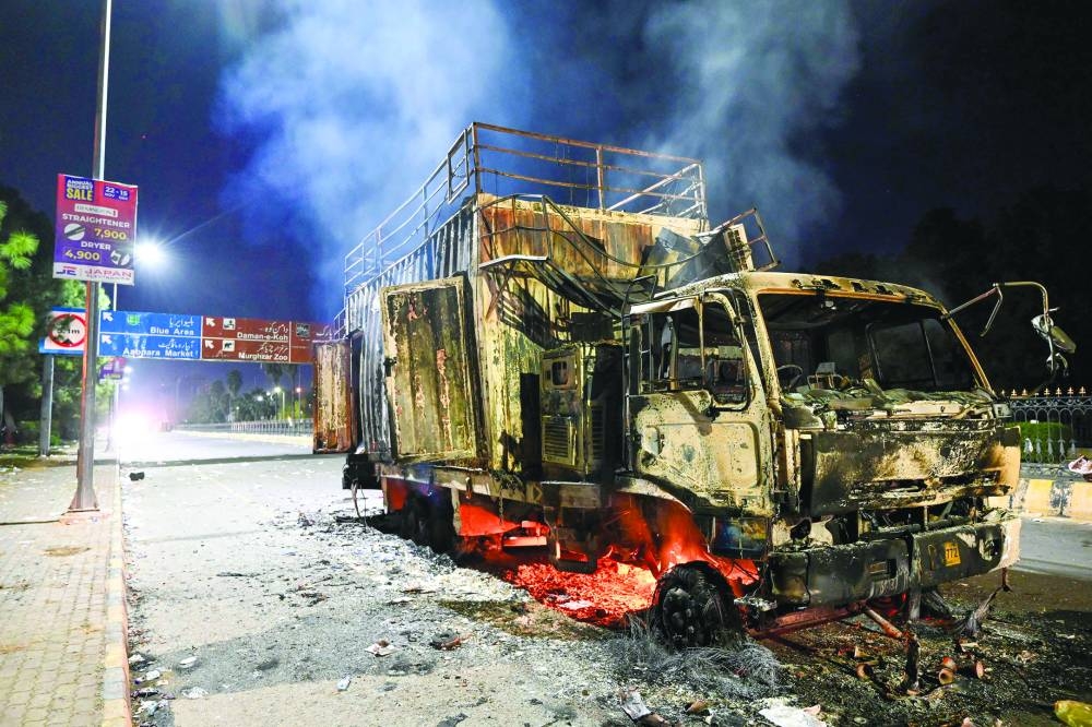 A rally truck used by Bushra Bibi, the wife of Pakistan’s former prime minister Imran Khan, burns near the Red Zone after a protest to demand Khan’s release in Islamabad.  (AFP)