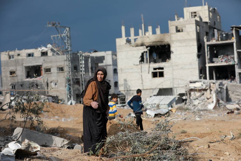 A Palestinian woman reacts near damaged buildings after Israeli forces withdrew from a part of Nuseirat, in Nuseirat, central Gaza Strip, on Friday. REUTERS