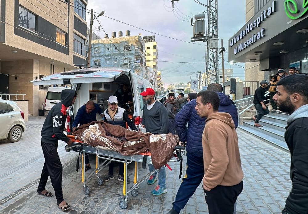 People move the body of a Palestinian outside a hospital after an Israeli strike, in Nuseirat in the central Gaza Strip, on Friday. REUTERS