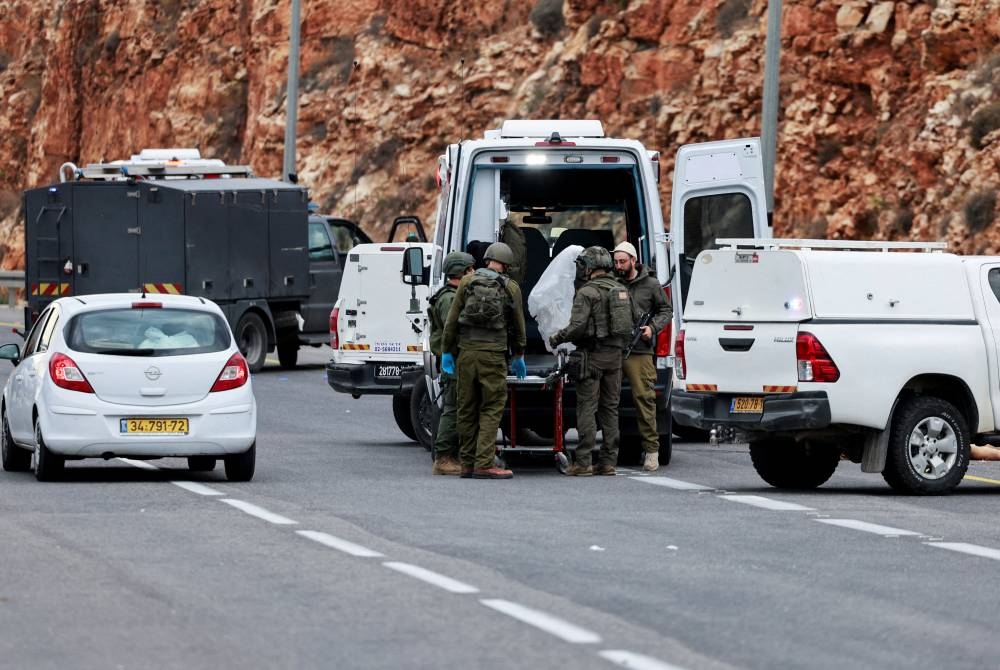 Israeli security forces members work next to an ambulance at the scene of a shooting attack near the Jewish settlement of Ariel, in the Israeli-occupied West Bank, on Friday. REUTERS