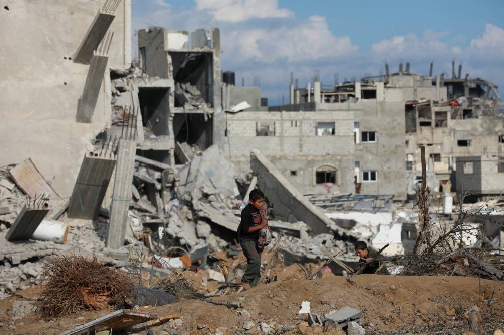 Palestinian children walk near a destroyed building after Israeli forces withdrew from a part of Nuseirat, following a ground operation, in Nuseirat, central Gaza Strip, on Friday. REUTERS