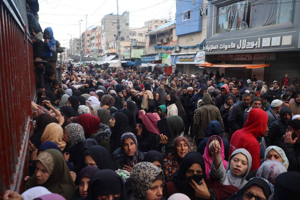 Palestinians wait for bread outside a bakery in the Nuseirat camp in central Gaza on Wednesday. AFP
