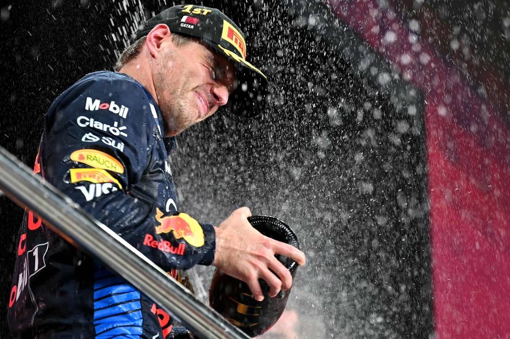 Red Bull Racing's Dutch driver Max Verstappen celebrates at the podium. AFP