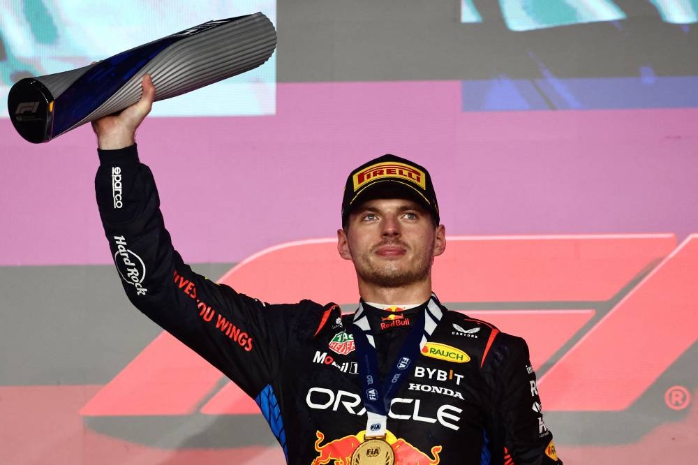 Red Bull's Max Verstappen celebrates with a trophy on the podium after winning the Qatar Grand Prix. REUTERS