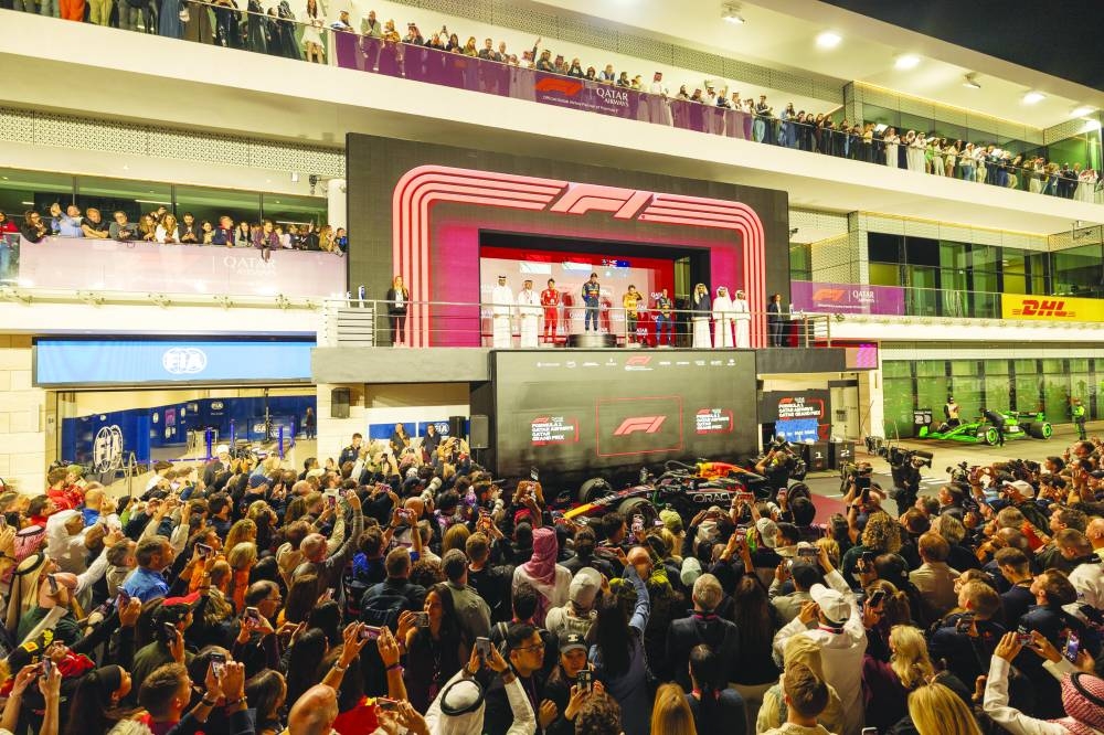 
Fans and race photographers take pictures at the prize distribution ceremony after Max Verstappen won the Qatar Grand Prix at Lusail International Circuit yesterday. 