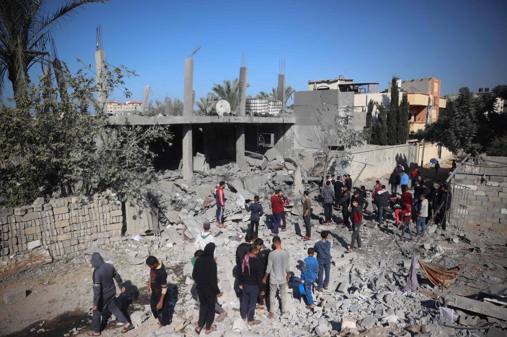 Palestinians inspect the destruction at the site of an Israeli strike that targeted a home in the Bureij refugee camp in the central Gaza Strip on Monday. AFP