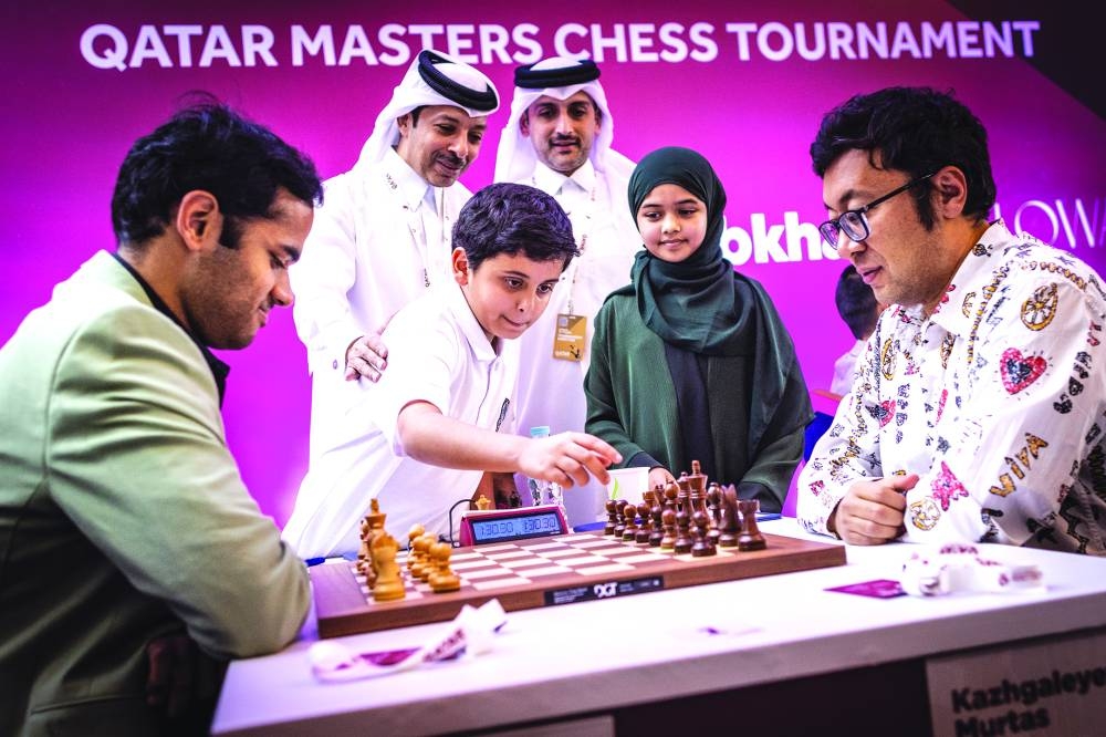 A young fan makes a ceremonial move before India’s Arjun Erigaisi’s (left) match against Murtas Kazhgaleyev of Kazakhstan at the Qatar Masters in Doha on Wednesday. Mohammed al-Mudahka, President of the Qatar Chess Association is also in the picture.