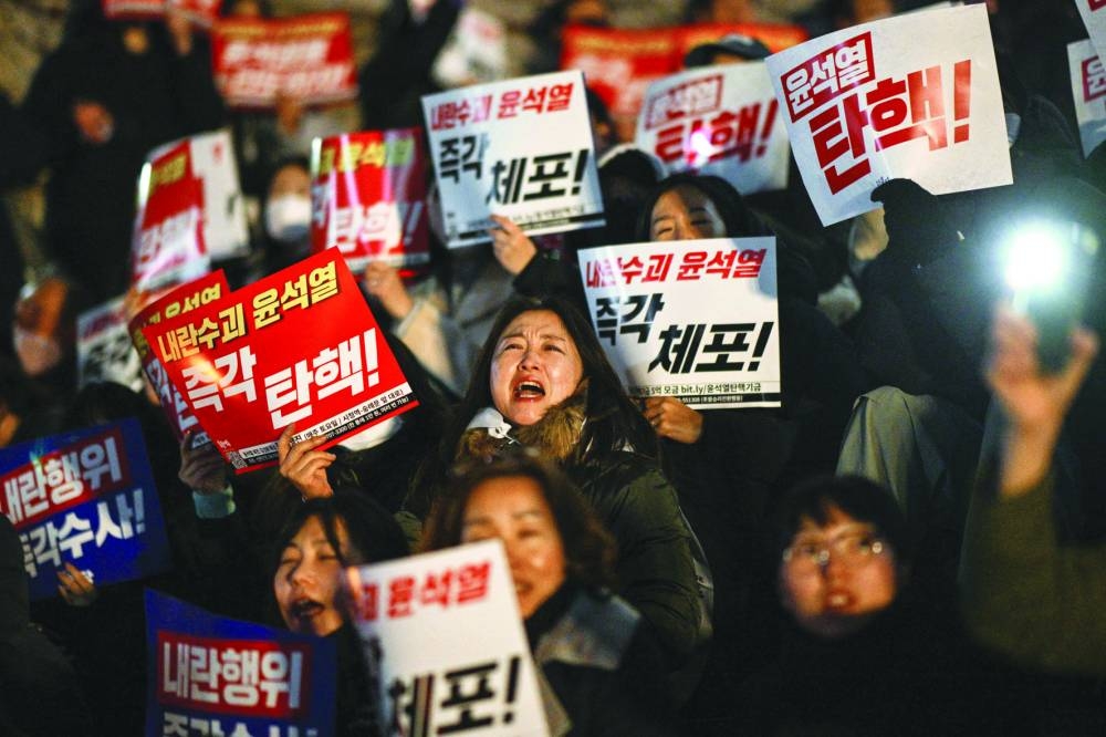 
People take part in a protest calling for the resignation of South Korea President Yoon Suk-yeol at the National Assembly in Seoul yesterday. Thousands marched on parliament in South Korea’s capital. (AFP) 