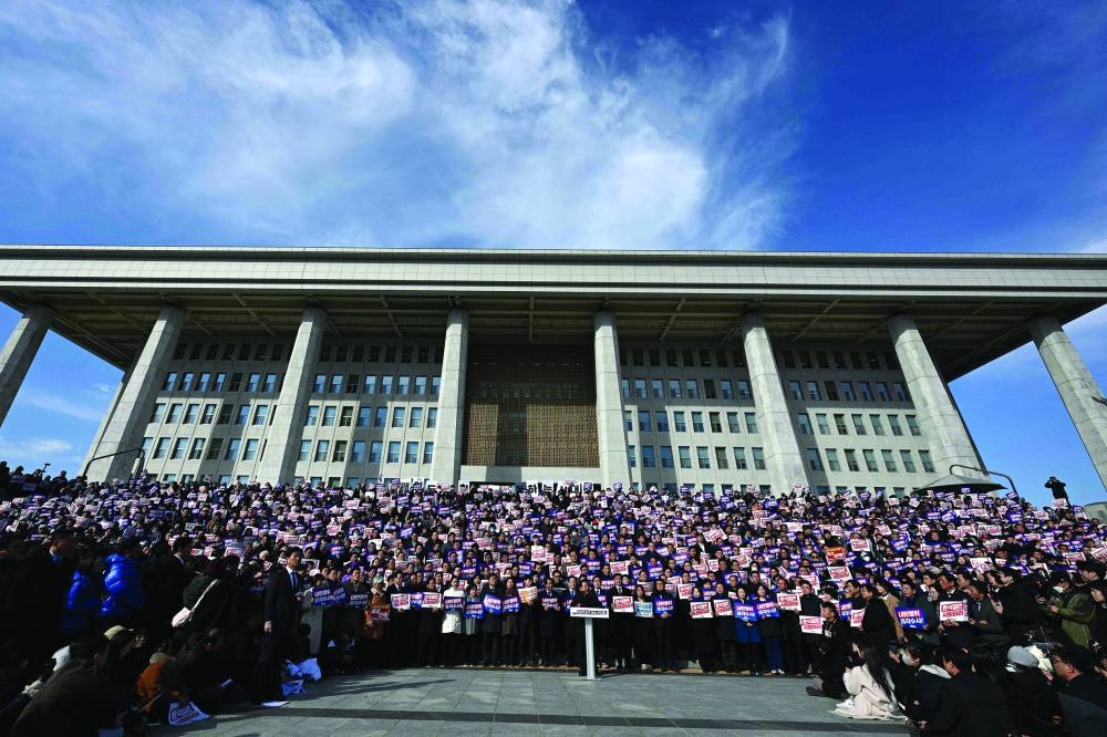 
Lawmakers and South Korea’s main opposition Democratic Party members hold placards reading “Yoon Suk-yeol should resign!” during a rally against President Yoon Suk-yeol at the National Assembly in Seoul yesterday, after martial law was lifted in South Korea. (AFP) 