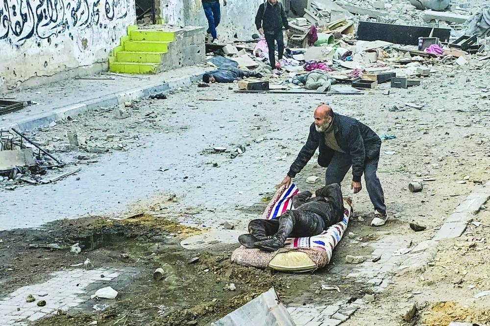 A Palestinian man uses a mattress to pull away a victim following a Israeli strike that hit the Kamal Adwan hospital in Beit Lahia in the northern Gaza Strip on Friday.