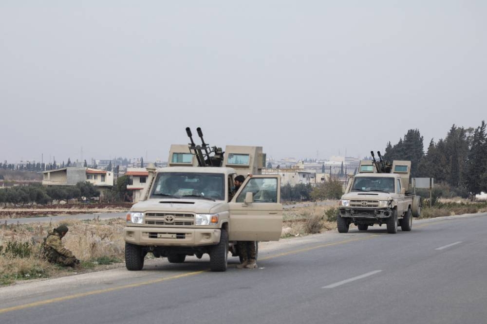 A rebel fighter sits near a vehicle in Homs countryside, after Syrian rebels pressed their lightning advance on Saturday. REUTERS