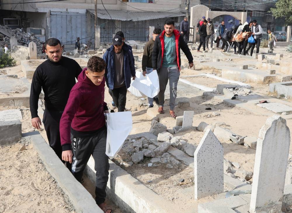 Mourners carry bodies of Palestinians killed in an Israeli airstrike at a cemetery in Nuseirat refugee camp in the central Gaza Stri, on Saturday. REUTERS