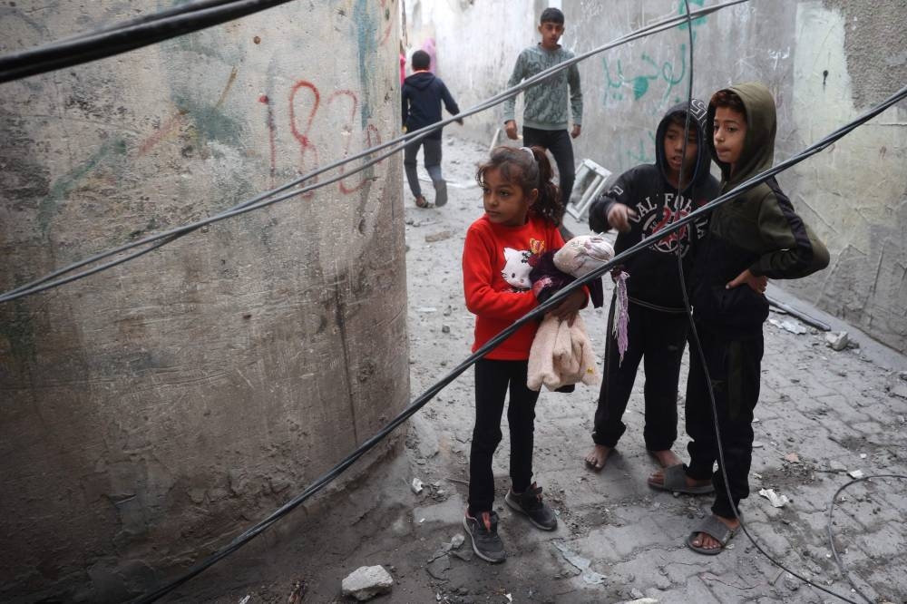 Palestinian children stand in an alley in the Nuseirat refugee Camp in the central Gaza Strip, on Saturday. AFP
