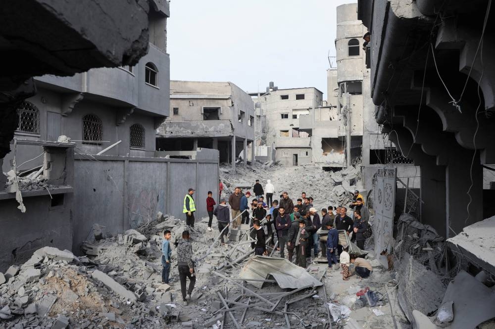 Palestinians inspect damage at the site of an Israeli strike on a house at the Nuseirat refugee camp in the central Gaza Strip, on Saturday. REUTERS