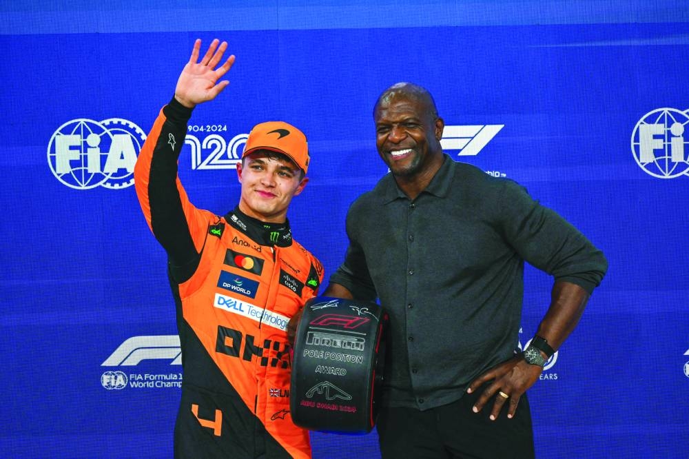 McLaren’s British driver Lando Norris (left) receives the pole trophy from US actor Terry Crews at the end of the qualifying session ahead of the Abu Dhabi Formula One Grand Prix at the Yas Marina Circuit in Abu Dhabi on Saturday. (AFP)