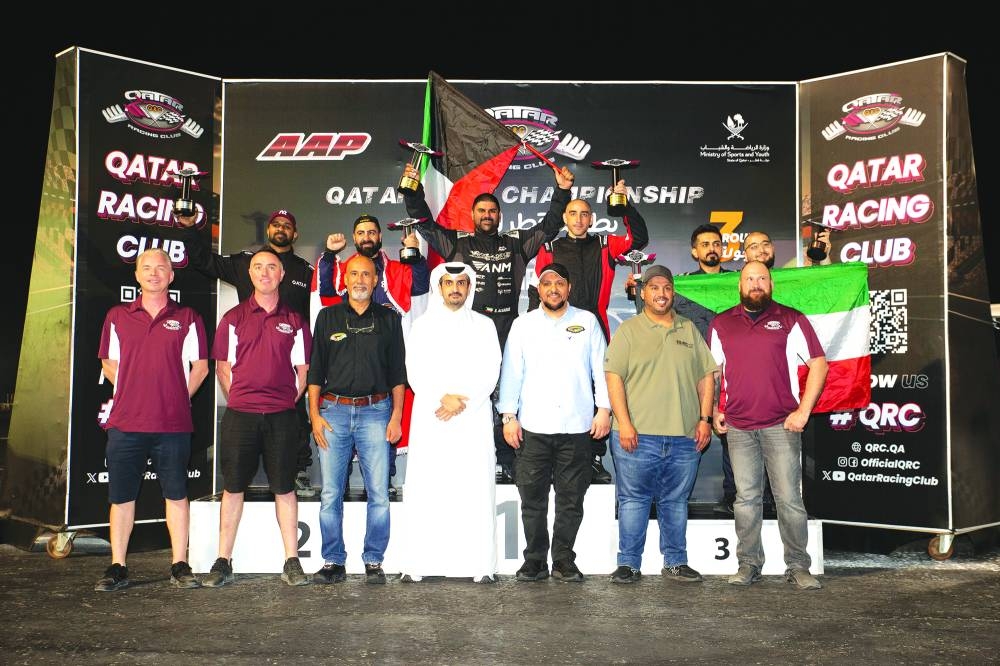 
QRC Director Sheikh Jabor bin Khaled al-Thani and members of the Basel Salem al-Sabah Club pose with the winners of the third round of the Qatar Drift Championship. 