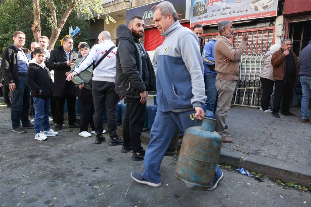 People queue to fill their gas cylinders, after rebels seized the capital and ousted Syria's Bashar al-Assad, in Damascus, Syria, on Monday. REUTERS