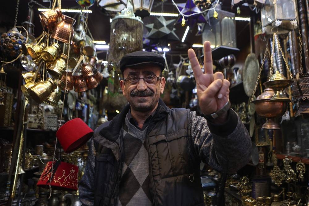 A Syrian vendor flashes the victory sign at the Hamidiyeh Souq in the Syrian capital Damascus, on Monday. AFP