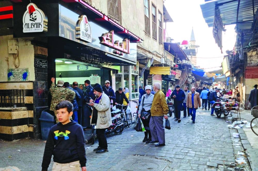 People shop at a market in Damascus Monday.