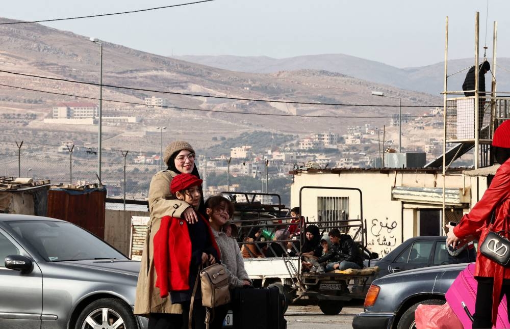 People smile for a picture at the Masnaa border crossing between Lebanon and Syria, on Tuesday. REUTERS