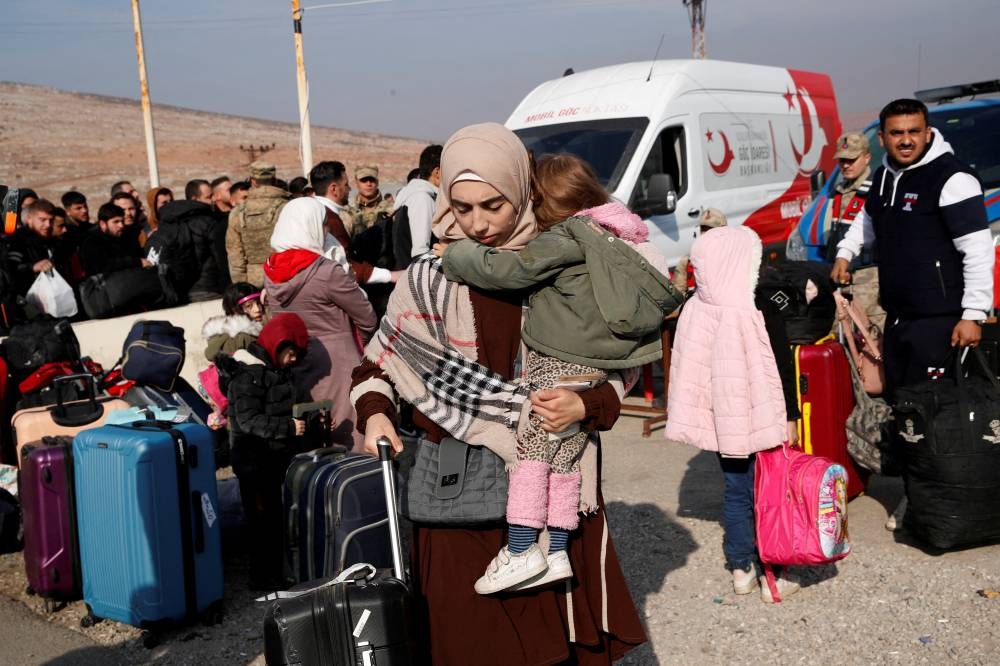 Syrian migrants wait at the Cilvegozu border gate to cross into Syria, in the Turkish town of Reyhanli in Hatay province, on Tuesday. REUTERS
