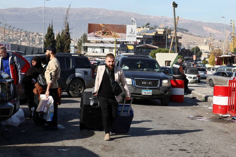 A man walks with his belongings as he attempts to cross into Syria, at the Masnaa border crossing between Lebanon and Syria, on Tuesday. REUTERS