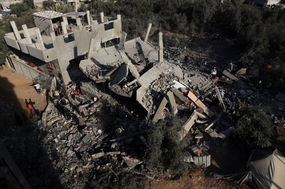 Palestinians gather at the site of an Israeli strike on a house, in Nuseirat, central Gaza Strip, on Wednesday. REUTERS