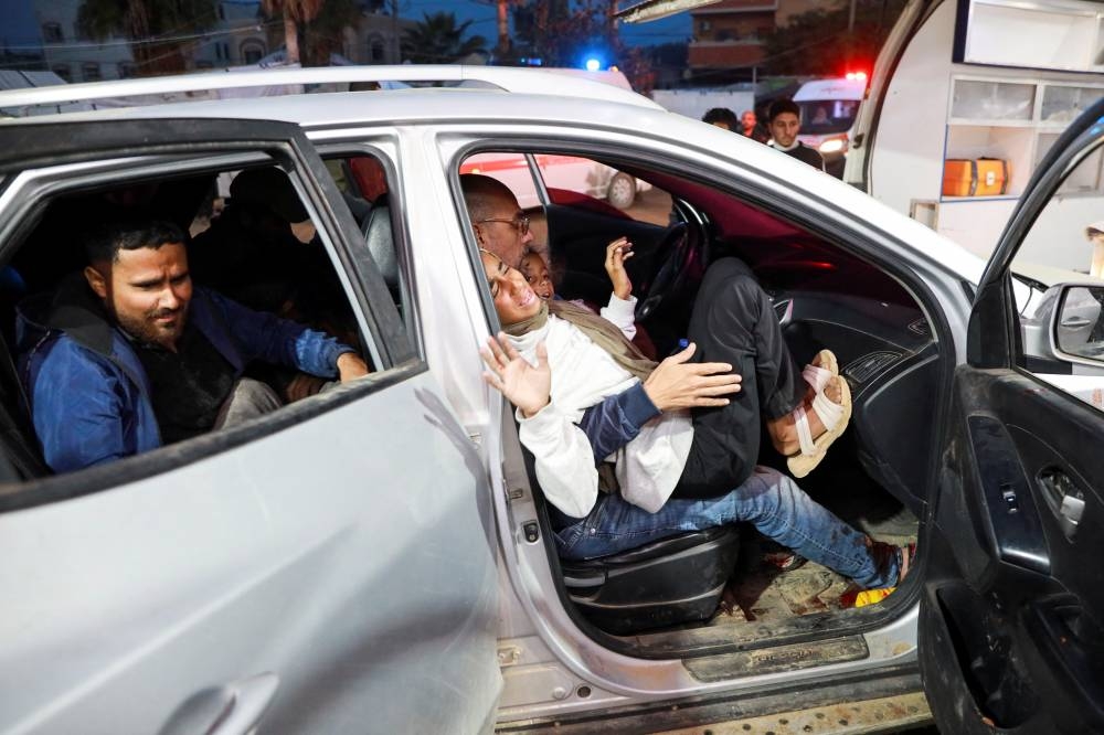 A wounded Palestinian reacts in a vehicle, in the aftermath of an Israeli strike, in Deir Al-Balah in the central Gaza Strip, on Wednesday. REUTERS