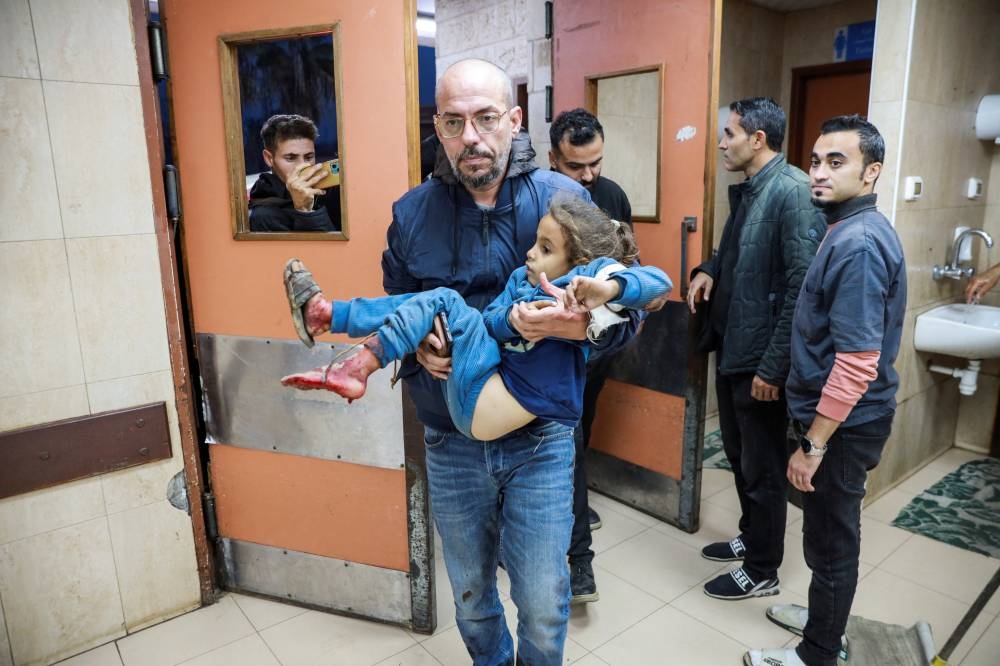 A person carries a wounded Palestinian at a hospital, in the aftermath of an Israeli strike, in Deir Al-Balah in the central Gaza Strip, on Wednesday. REUTERS