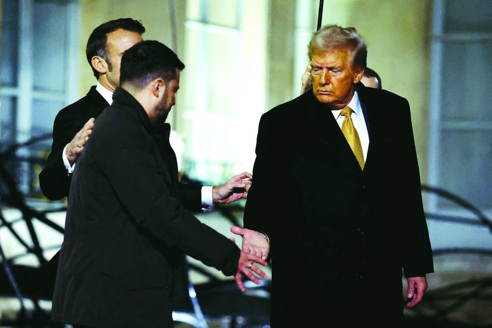 
US President-elect Donald Trump shakes hands with Ukrainian President Volodymyr Zelensky as they leave after a trilateral meeting with French President Emmanuel Macron at the Elysee Palace in Paris on Saturday. (Reuters) 