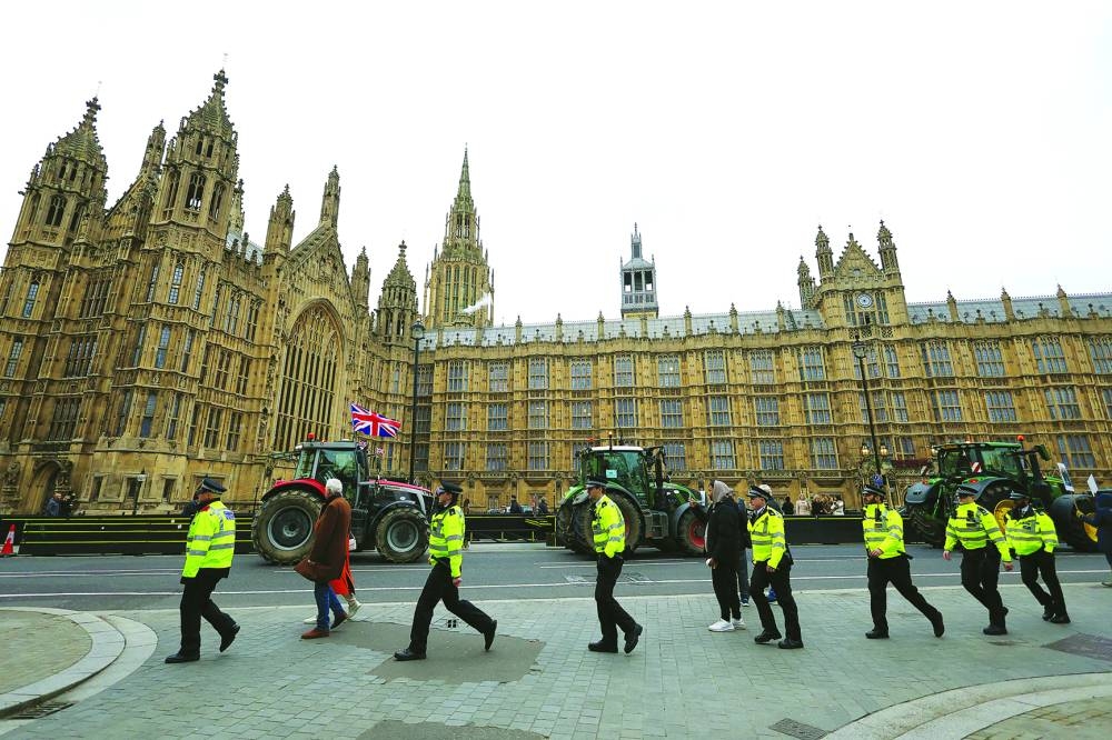 Police officers walk, as farmers in tractors take part in a demonstration by the Palace of Westminster, in London, Britain, on Wednesday.