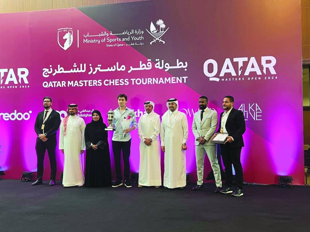 
Qatar Chess Association President Mohamed al-Mudahka, Director of Public Relations, Social Responsibility and Sponsorships at Ooredoo Sabah Rabia al-Kuwari and other officials pose with Qatar Masters winner Andrey Esipenko at the podium ceremony. 