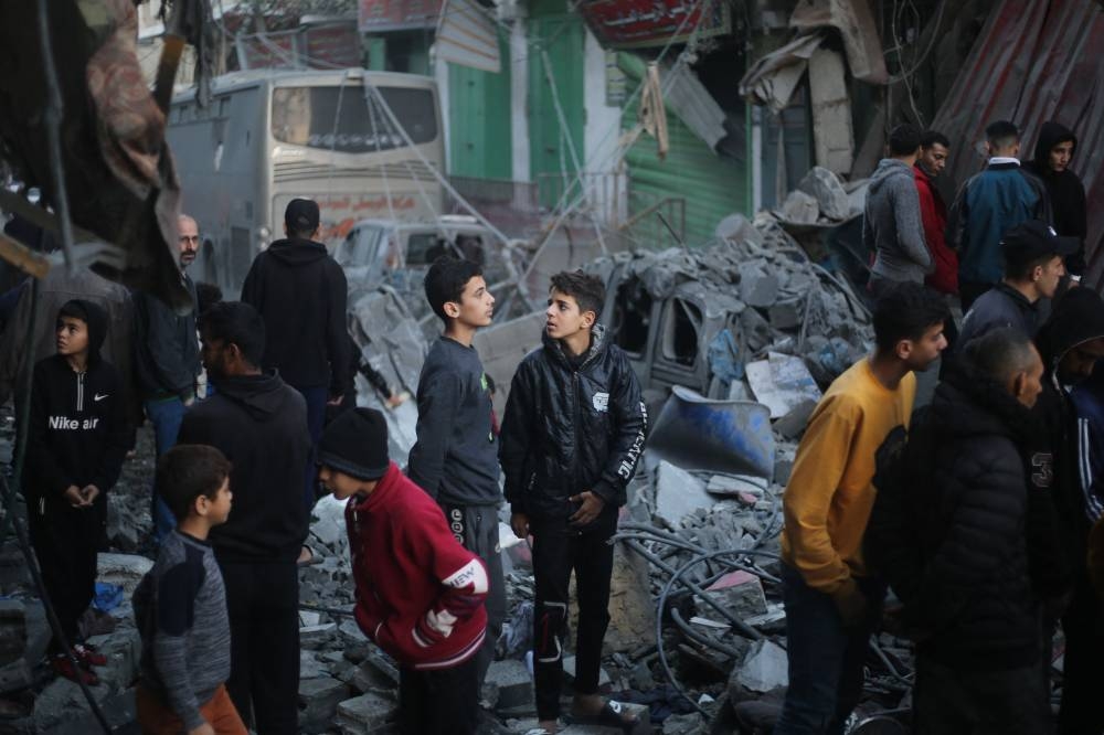 Palestinians stand next to the rubble of a building after an Israeli airstrike on the Nuseirat refugee in the central Gaza Strip on Friday. AFP