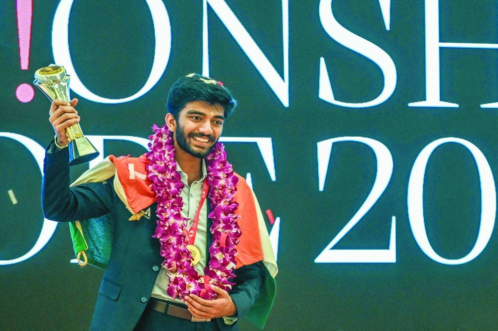 Gukesh Dommaraju celebrates with the World Chess Championship 2024 trophy during an award ceremony in Singapore on Friday. (AFP)